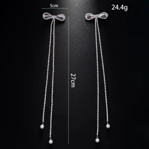 Rhinestone bow hair clip with long tassel and pearl pendant, elegant detail display.