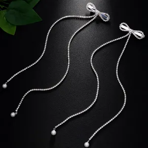 Rhinestone bow long tassel hair clip detail shot showing sparkling crystal chains and pearl drops.