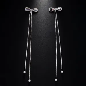 Detailed view of sparkling rhinestone bow tassel hair clip with elegant pearl drops for styling.
