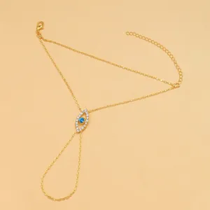 Pulsera de mano mal de ojo dorada con brillantes diamantes de imitación azules y claros.