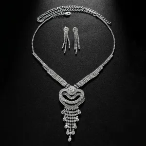 Close-up of sparkling rhinestone heart tassel necklace and earrings set for evening party wear.