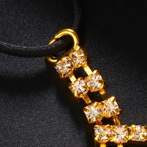 Gold rhinestone tassel chain detail, sparkling crystal fashion jewelry accessory.