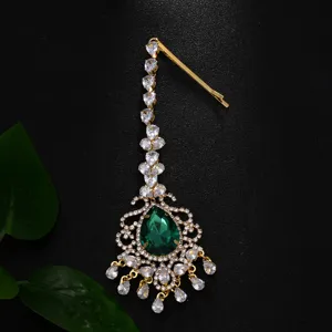Traditioneller indischer Haarschmuck mit grünem Edelstein und funkelnden Kristallzirkonia Steinen.