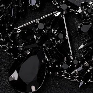 Primo piano sui dettagli della maschera in strass nero, cristalli brillanti con montatura.