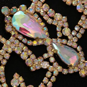Detailed shot of sparkling iridescent rhinestone body chain in gold tone for sexy party look.