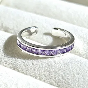 Close-up detail of a silver-tone open ring featuring purple square-cut crystal stones.
