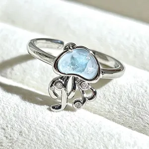 Silver open ring close-up featuring cute jellyfish design with light blue gem and sparkling stones.