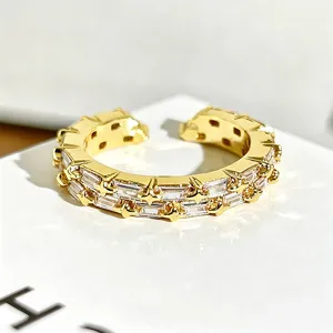 Anillo abierto dorado con circonitas talla baguette y estrellas joya de lujo elegante.