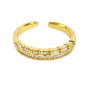 Primer plano detallado de un anillo abierto dorado con circonitas brillantes talla baguette.