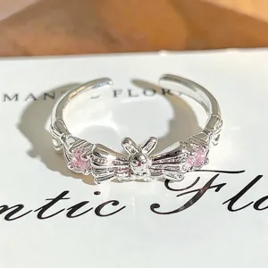 Close-up detail of silver open ring featuring cute bow and sparkling pink cubic zirconia stones.