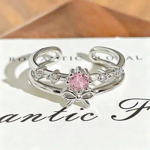 Silver double band open ring detail, featuring a sparkling pink cubic zirconia and cute bow accent.