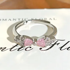 Close-up of the silver bow ring featuring sparkling pink heart cubic zirconia details.
