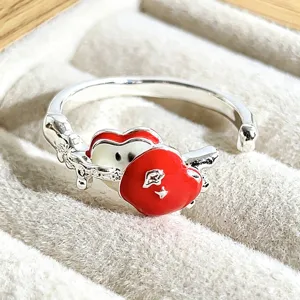 Close-up detail of the sweet red apple enamel ring with silver open band in jewelry box.