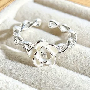 Exquisite white enamel camellia flower open silver ring featuring an elegant twisted band design