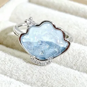 Exquisite detail shot of a sweet cloud shaped enamel ring with shimmering blue glitter stones.