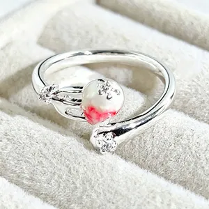 Close-up detail of sweet style open ring featuring pearl, enamel fruit motif and crystal.