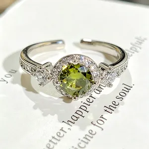 Hermoso primer plano detallado de un anillo abierto de plata con circonita verde.