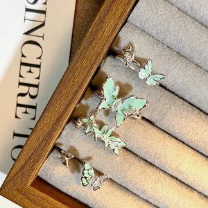 Nahaufnahme von minzgrünen Emaillierte Schmetterling Zirkon offenen Ringen auf Schmuck.