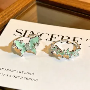 Detailansicht von mintgrünen Schmetterlings- und Blatt-Zirkonringen aus E-mail, elegantes Design.
