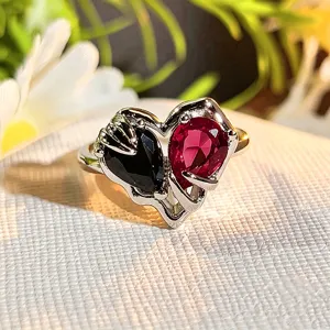 Detailed shot of a chic heart-shaped dual-color zircon open ring on white textured fabric.