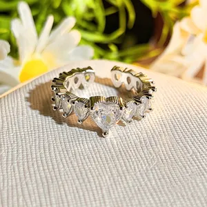 Silver open ring with sparkling heart-shaped cubic zirconia crystals and vintage milgrain edge detail.
