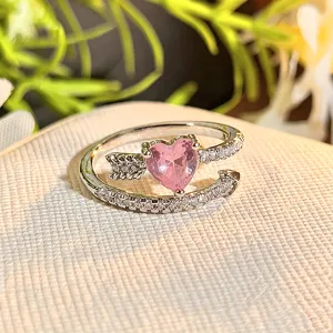 Detailed close-up of a pink heart zircon arrow open ring, sparkling cubic zirconia pavé.