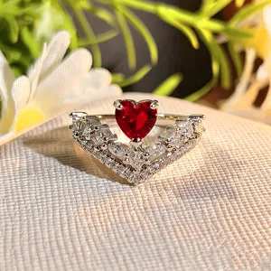 Close-up of heart-shaped red zircon open ring with sparkling crystal V-shaped details.