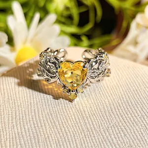 Close-up view of heart-shaped yellow zircon silver open ring with intricate floral details.