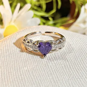 Close-up of a delicate purple heart cubic zirconia open ring with sparkling pavé stones.