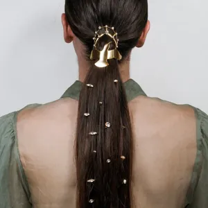 Primer plano de horquilla dorada de pájaro con pedrería, accesorio elegante para el pelo.