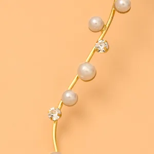 Detalle de collar gargantilla chapado en oro con perlas elegantes y pedrería brillante.