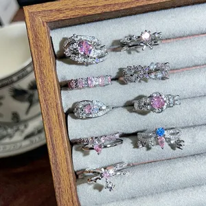 Close-up detail of dainty pink blue zircon silver stackable rings set in jewelry velvet tray
