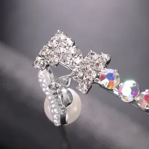 Close-up detail of rhinestone bow and pearl eyewear accessory, sparkling crystals and chic design.