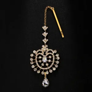 Gros plan détail du pendentif de chaîne de cheveux Maang Tikka indien en strass avec pince dorée.