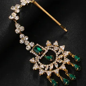 Detail exquis de maang tikka indien traditionnel avec des strass et des pierres vertes.