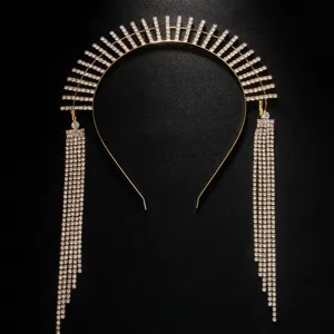 Detailed view of the luxury gold rhinestone sunburst halo headband with long fringe tassels.