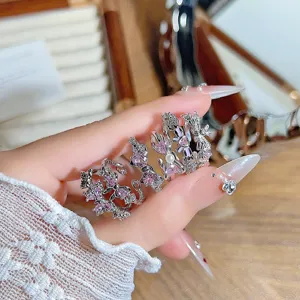 Detailed shot of sweet and cool pink zircon bow open rings, stacked for a trendy look.