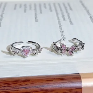 Close-up of sweet cool style silver open rings featuring pink zircon heart wings and butterflies.