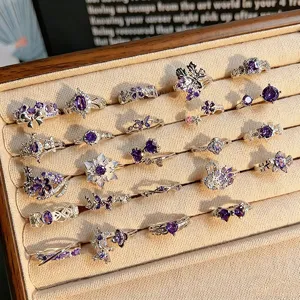 Detailed shot of exquisite purple zircon silver rings featuring cute floral and butterfly designs.