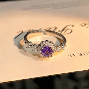 Detailed view of the flower-shaped open ring featuring a sparkling purple central zircon.