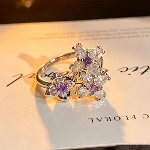 Silver open ring featuring purple and clear zirconia stones in delicate floral cluster designs.