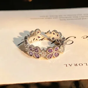 Silver-tone open ring featuring purple zirconia stones in a delicate floral clover design.