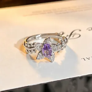 Close-up detail of a delicate floral open ring featuring a sparkling purple cubic zirconia.