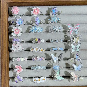 Detailed shot of multi-style colorful enamel flower and butterfly open rings set.