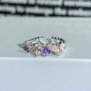 Silver open ring featuring colorful enamel flowers and sparkling cubic zirconia stones.