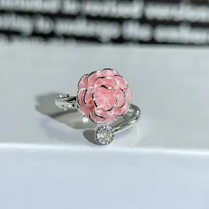Detail view of a silver adjustable ring featuring a pink enamel flower and sparkling cubic zirconia.