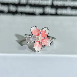 Silver cherry blossom open ring with pink enamel, central pearl, and sparkling cubic zirconia.