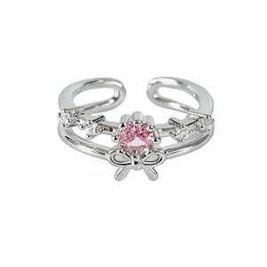 Silver open ring featuring a pink central zircon stone, clear stones, and a cute bow design.