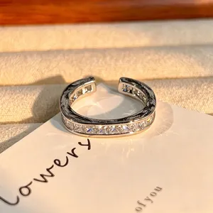 Gedetailleerde close-up van open ring met vierkante zirkonia en vintage textuur.