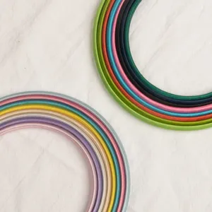 Vue détaillée de cerceaux de cheveux en satin coloré montrant des teintes vives et douces.